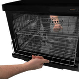 Chauffe-serviettes noir de 23 L avec des grilles en métal, offrant un accès facile grâce à une porte en verre transparent et une finition élégante
