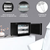 Chauffe-serviettes noir de 23 L avec porte ouverte, affichant des serviettes blanches et une lampe UV pour désinfection, sur fond gris