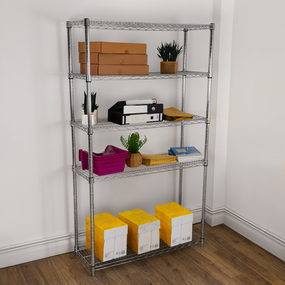 Étagère en fil d'acier argenté de 180 cm, avec quatre niveaux, décorée de plantes et de boîtes en carton, sur un sol en bois clair