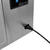 Prise électrique noire connectée à un appareil en acier inoxydable, avec un panneau de contrôle affichant des instructions claires