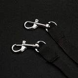 Crochets en métal argenté sur une sangle noire, conçus pour attacher solidement la poussette jogger pour animal de compagnie