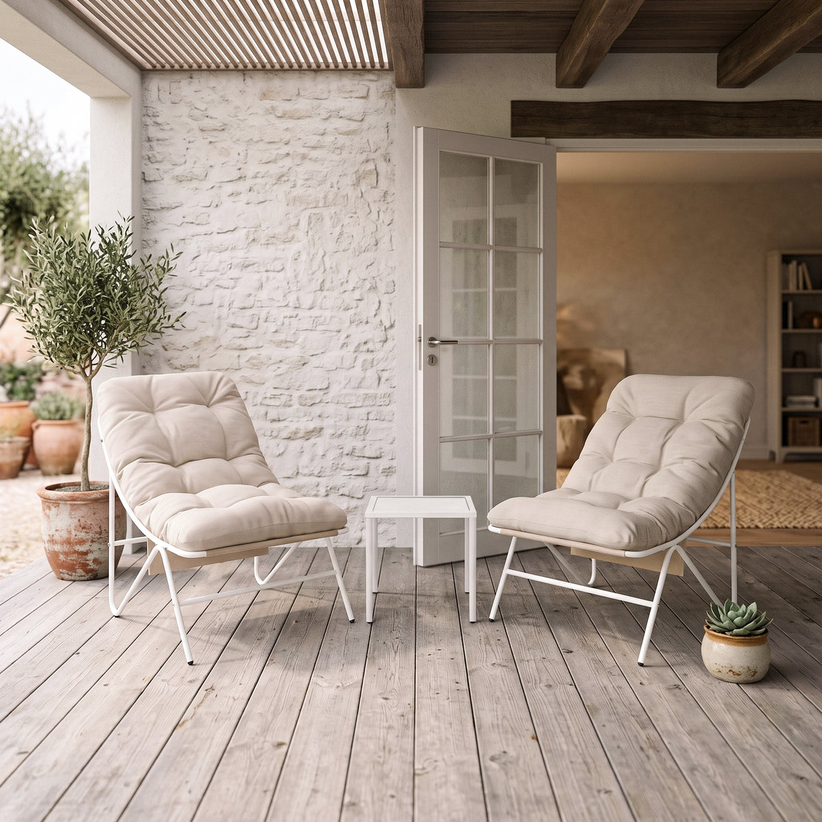 Ensemble bistro 3 pièces crême avec deux fauteuils rembourrés et une table blanche, sur un patio en bois, entouré de plantes décoratives