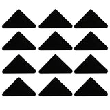 Douze triangles noirs en caoutchouc, disposés en grille, offrant une surface antidérapante pour un maintien sécurisé sur l'établi