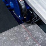 Scie de carrelage sur table avec un plateau en métal gris, ligne rouge pour le guidage, et un moteur puissant de 800 W