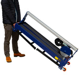 Scie de carrelage sur table, couleur bleu, avec roulettes, poignée de transport, et lame circulaire visible, conçue pour un usage facile