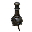 Cheminée de jardin en fonte noire avec une finition texturée, forme arrondie, cheminée haute et grille métallique pour une ambiance chaleureuse