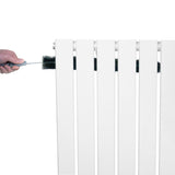 Radiateur plat blanc à 1 panneau de 600 x 700 mm, avec une main tenant une brosse pour le nettoyage des lamelles