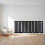 Radiateur plat gris anthracite à 1 panneau, design moderne avec finitions élégantes, installé sur un mur clair, près d'un fauteuil contemporain
