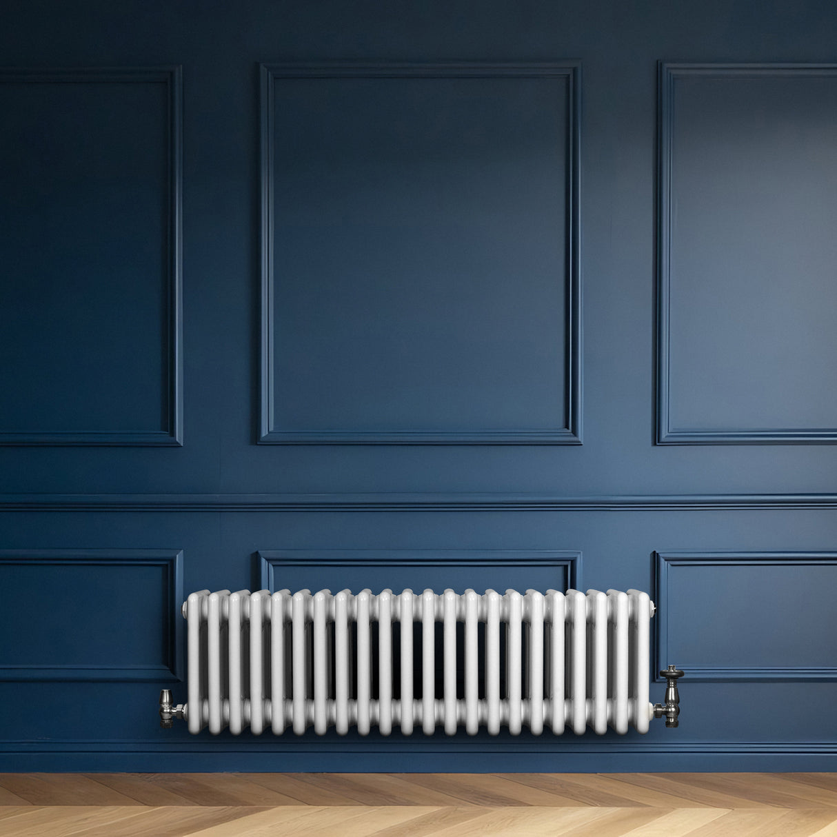 Radiateur traditionnel à 4 colonnes blanc, installé contre un mur bleu, avec un sol en bois clair et des détails architecturaux élégants