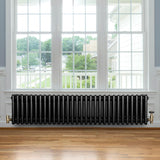 Radiateur traditionnel à 4 colonnes noir, 300 x 1370 mm, installé sous une fenêtre, avec un sol en bois clair et un cadre moderne