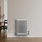 Radiateur traditionnel à 4 colonnes blanc, 600 x 425 mm, avec une finition lisse et brillante, installé sur un mur clair dans un intérieur moderne