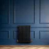 Radiateur traditionnel noir à 4 colonnes, finition lisse, installé sur un mur bleu, ajoutant une touche élégante à l'intérieur