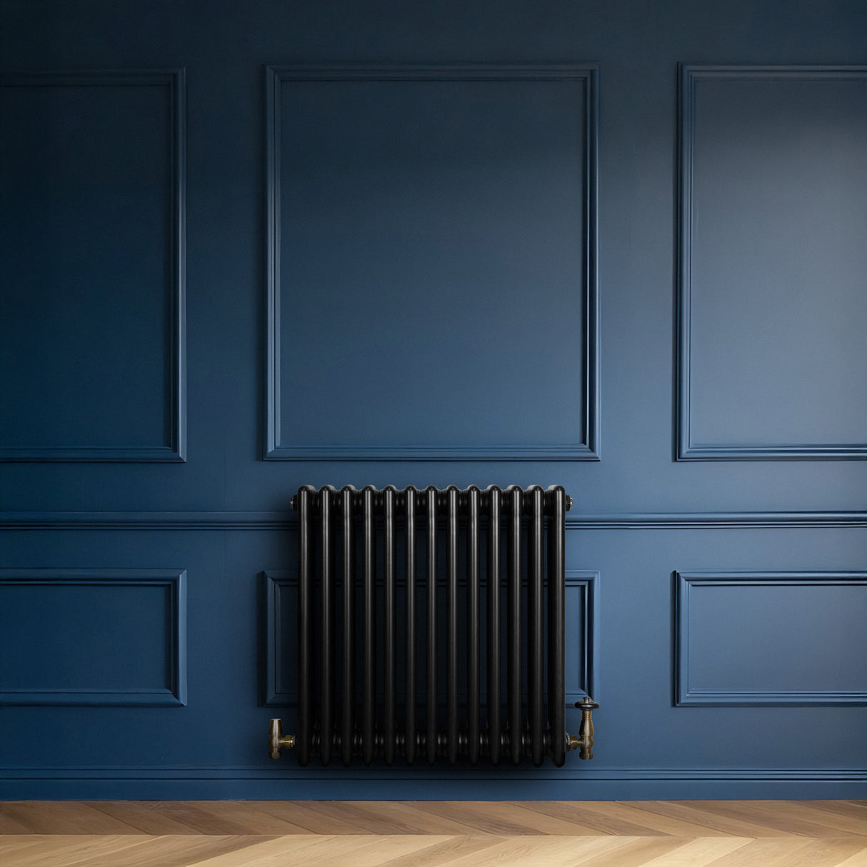 Radiateur traditionnel noir à 4 colonnes, installé contre un mur bleu, avec des détails dorés et un sol en bois clair