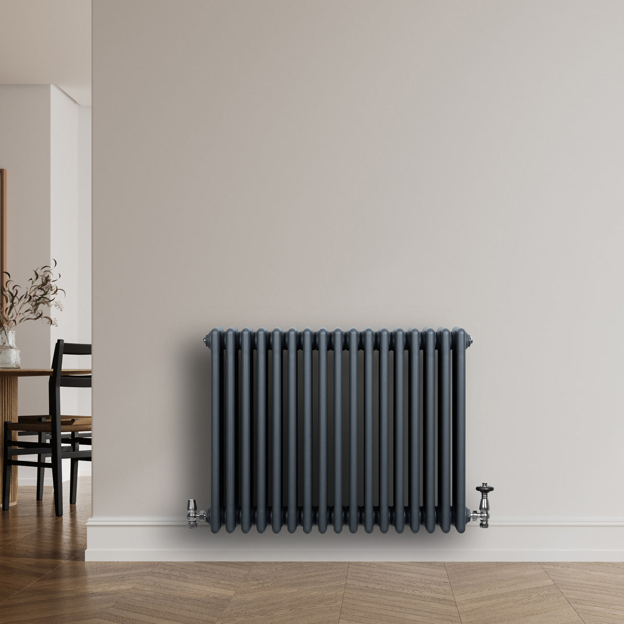 Radiateur traditionnel à 4 colonnes, gris anthracite, installé au mur, avec un design élégant et des finitions lisses, idéal pour un intérieur moderne
