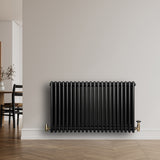 Radiateur traditionnel à 4 colonnes noir, 600 x 1010 mm, avec finition lisse et élégante, installé contre un mur clair en bois