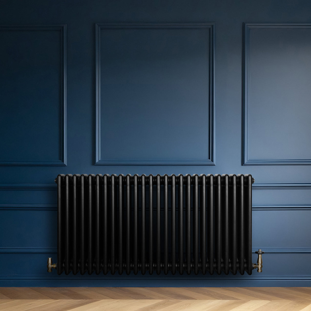 Radiateur traditionnel à 4 colonnes noir, installé contre un mur bleu, avec un sol en parquet clair et des détails élégants