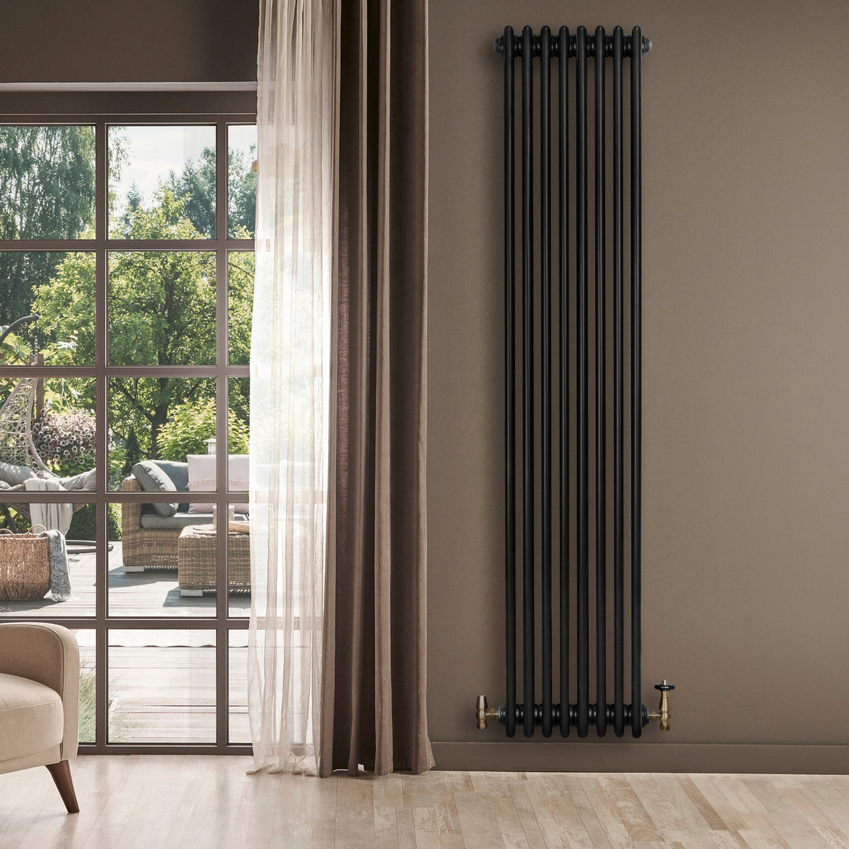 Radiateur traditionnel à 4 colonnes noir, 1800 x 380 mm, installé sur un mur beige, avec des fenêtres laissant entrer la lumière naturelle