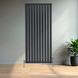 Radiateur plat à 1 panneau gris anthracite, 1600 x 700 mm, avec des lignes verticales et des pieds en métal, dans un intérieur moderne