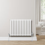 Radiateur à colonnes ovales blanc, 600 x 780 mm, avec finition lisse et supports chromés, installé contre un mur clair en bois