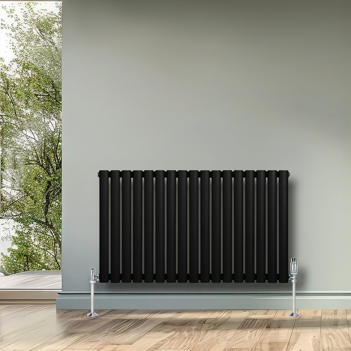 Radiateur à colonnes ovales noir, 600 x 1020 mm, avec un design élégant et moderne, installé sur un mur gris dans un intérieur lumineux