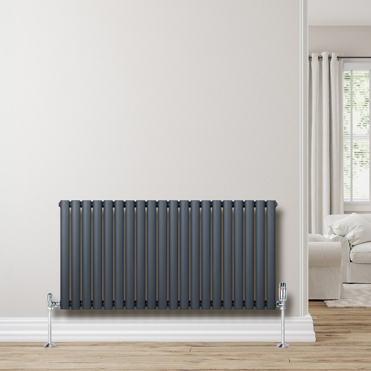 Radiateur à colonnes ovales gris anthracite, 600 x 1200 mm, installé contre un mur clair, avec un sol en bois et un intérieur moderne