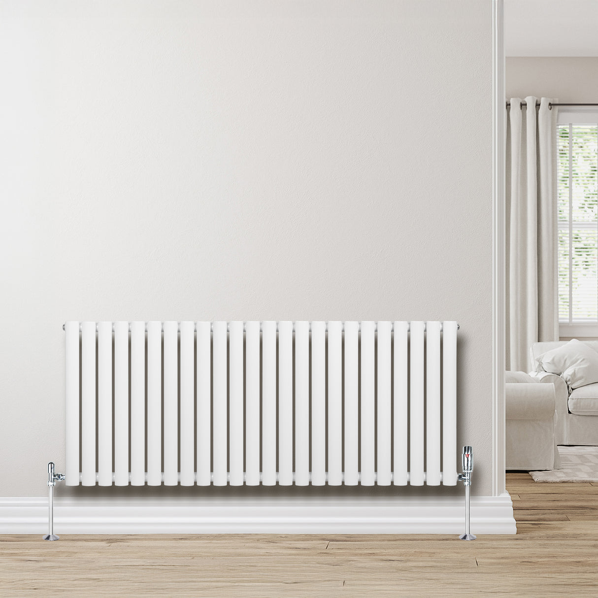 Radiateur à colonnes ovales blanc, 600 x 1440 mm, installé sur un mur clair, avec un sol en bois et un salon lumineux en arrière-plan