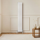 Radiateur à colonnes ovales blanc, 1600 x 240 mm, installé dans un intérieur moderne avec un sol en bois et un tapis doux