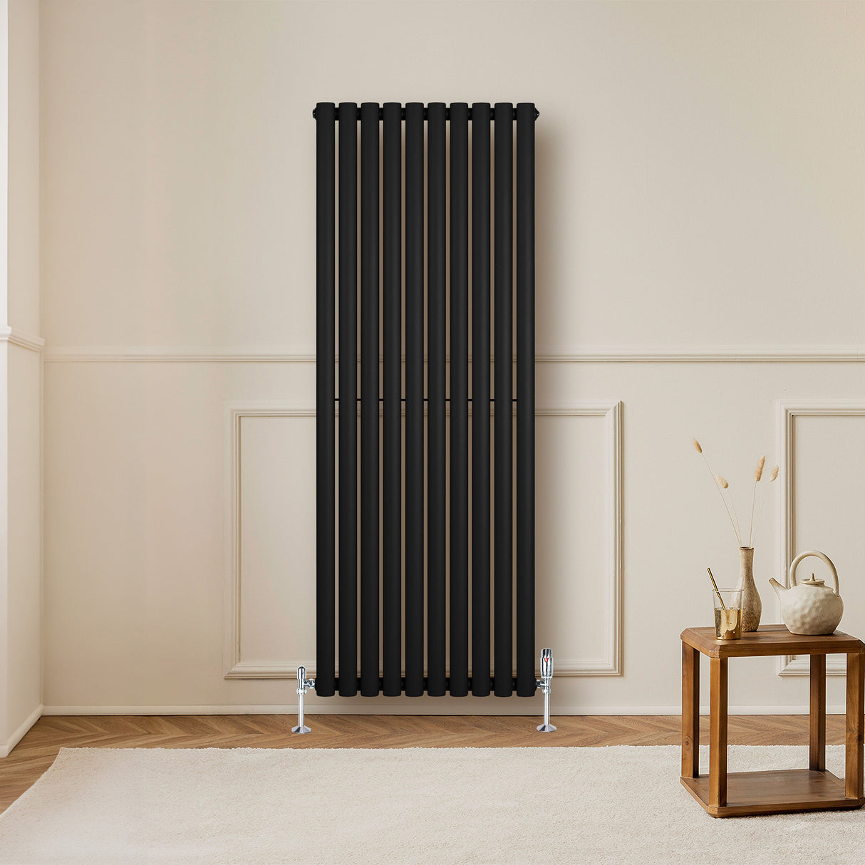Radiateur à colonnes ovales noir, 1600 x 600 mm, avec finition lisse, installé contre un mur dans un intérieur moderne et minimaliste