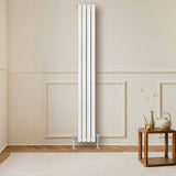 Radiateur à colonnes ovales blanc, 1800 x 240 mm, installé sur un mur beige, avec un sol en bois et une décoration minimaliste