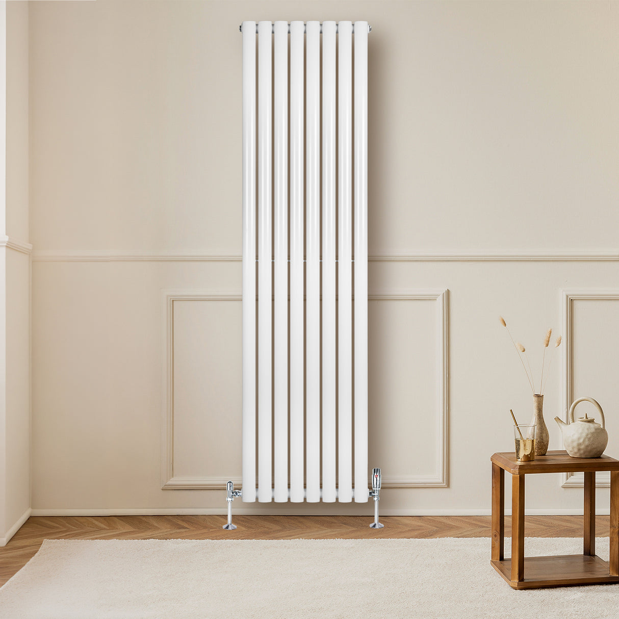 Radiateur à colonnes ovales blanc, 1800 x 480 mm, installé sur un mur beige, avec un sol en bois et une table en bois à proximité