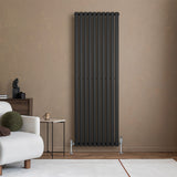 Radiateur à colonnes ovales noir, 1800 x 600 mm, installé sur un mur beige, ajoutant une touche moderne à un salon élégant