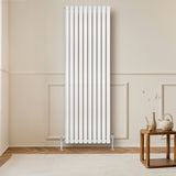 Radiateur à colonnes ovales blanc, 1800 x 600 mm, installé sur un mur clair, avec un sol en bois et une table en bois à proximité