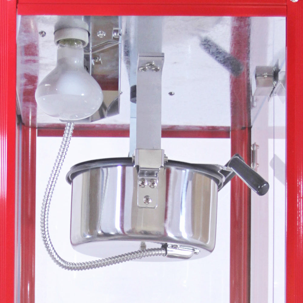 Machine à popcorn en acier inoxydable avec un bol brillant, éclairage intégré, et châssis rouge vif, idéale pour les fêtes