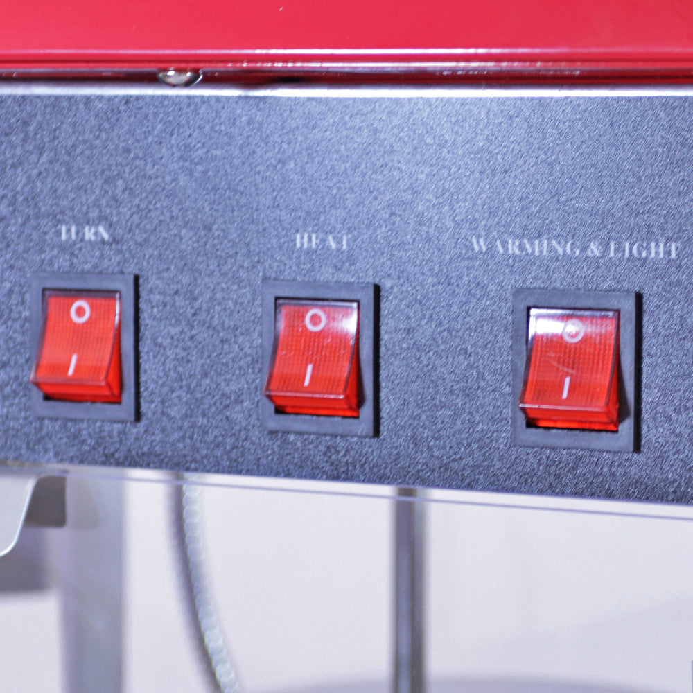 Panneau de contrôle avec trois interrupteurs rouges pour la machine à popcorn, la chaleur et l'éclairage, sur fond noir élégant