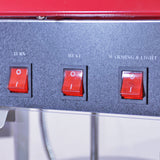Panneau de contrôle avec trois interrupteurs rouges pour la machine à popcorn, la chaleur et l'éclairage, sur fond noir élégant