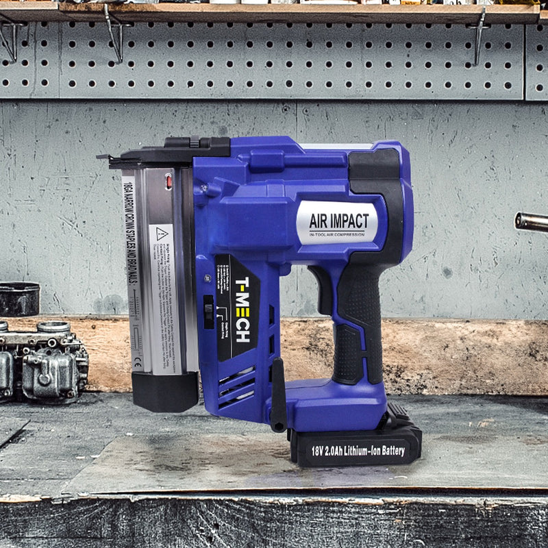 Agrafeuse-cloueuse électrique T-Mech en bleu avec batterie lithium-ion de 18V, posée sur un établi en bois avec outils en arrière-plan