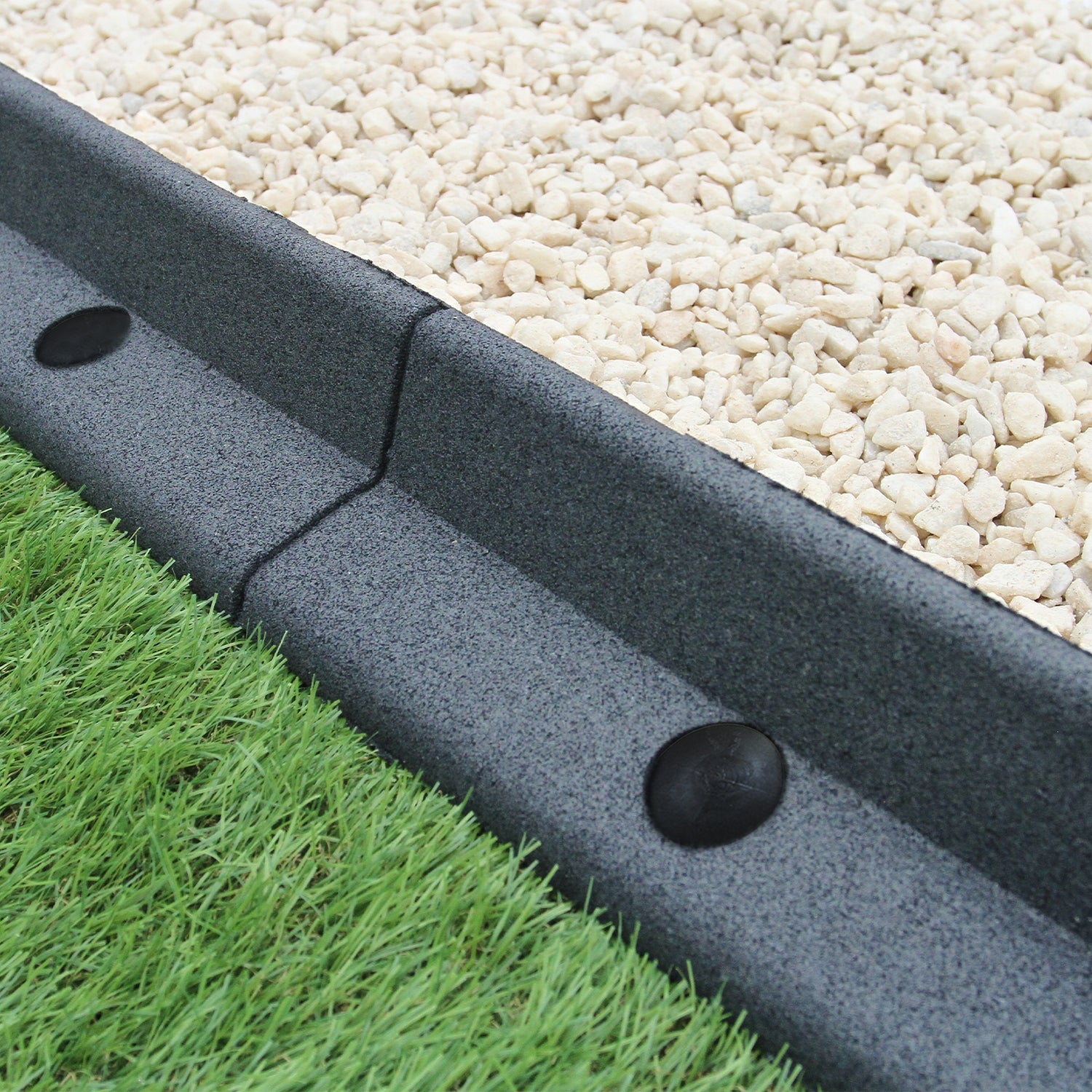 Bordures de pelouse flexibles grises de 1,2 m, en matériau durable, délimitent un espace avec gravier et gazon vert luxuriant