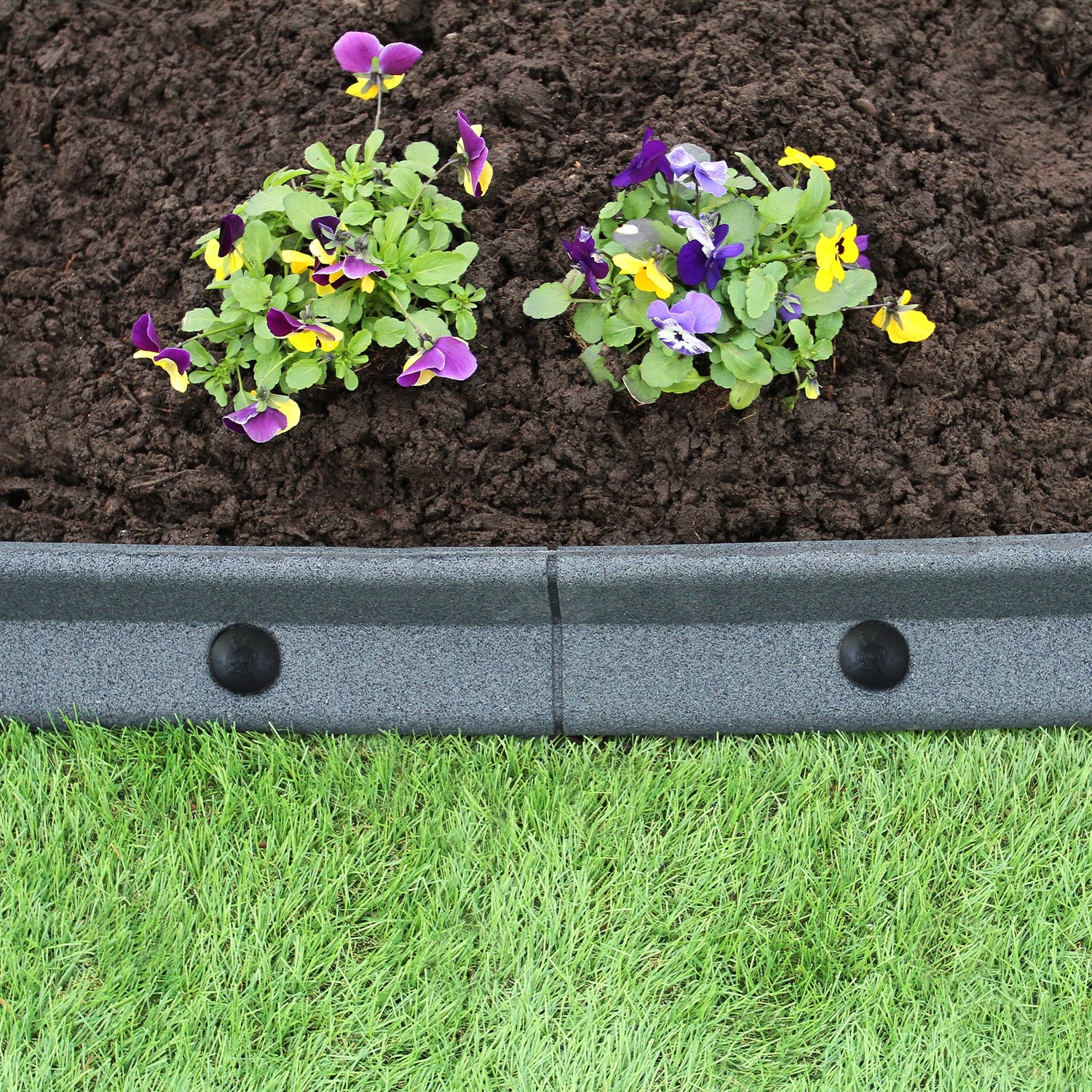 Bordures de pelouse flexibles grises de 1,2 m, entourant des fleurs colorées sur un sol brun, avec une texture lisse et durable