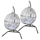Chaises suspendues en rotin gris avec coussins moelleux, structure en métal noir, design moderne et élégant, parfaites pour l'extérieur